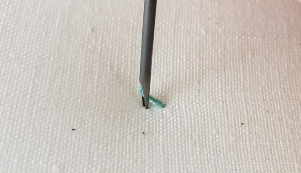 Slide the punch needle over a needles width