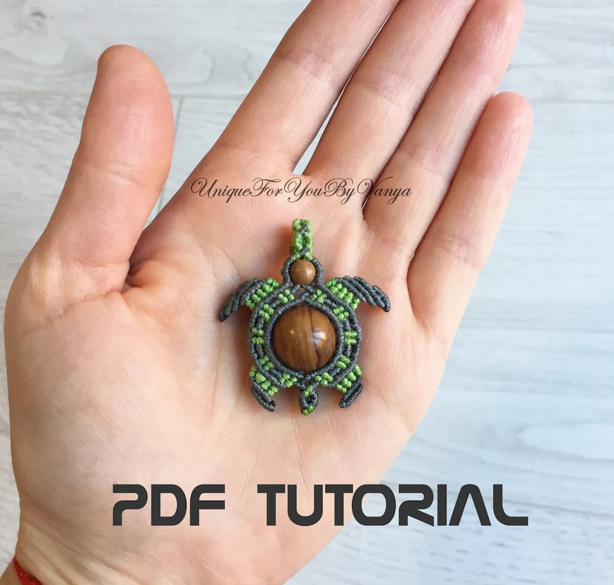 micro macrame turtle pendant in a persons hand