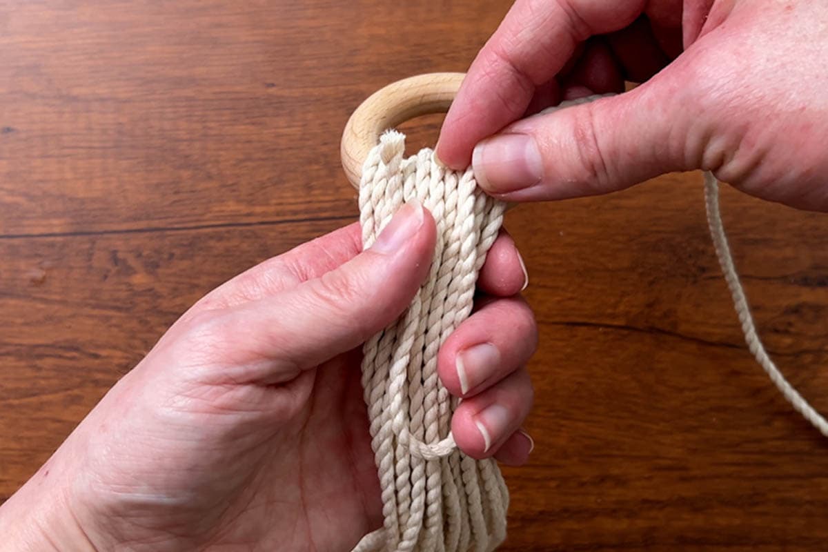 tying a wrapping knot at the top to secure the ring