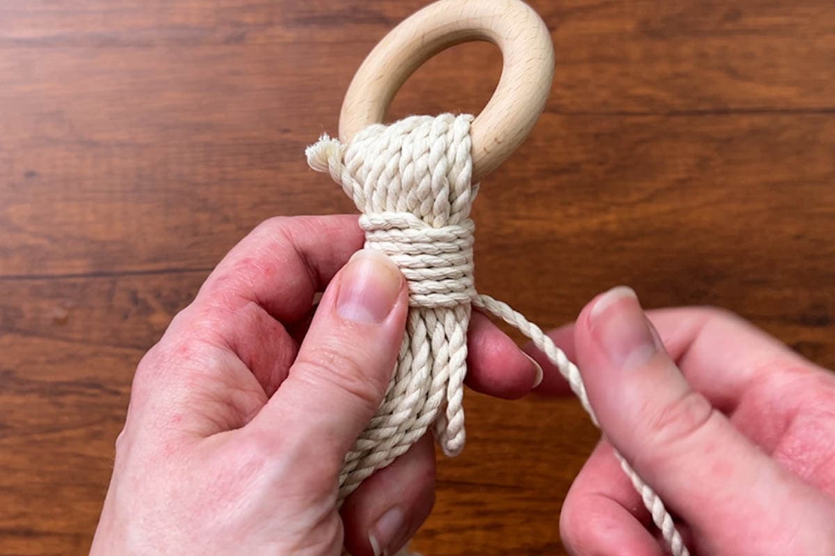 tying a wrapping knot at the top to secure the ring