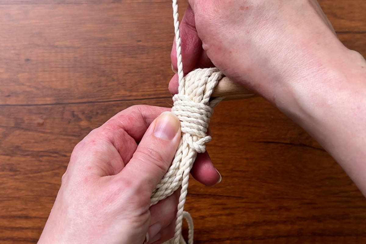 tying a wrapping knot at the top to secure the ring