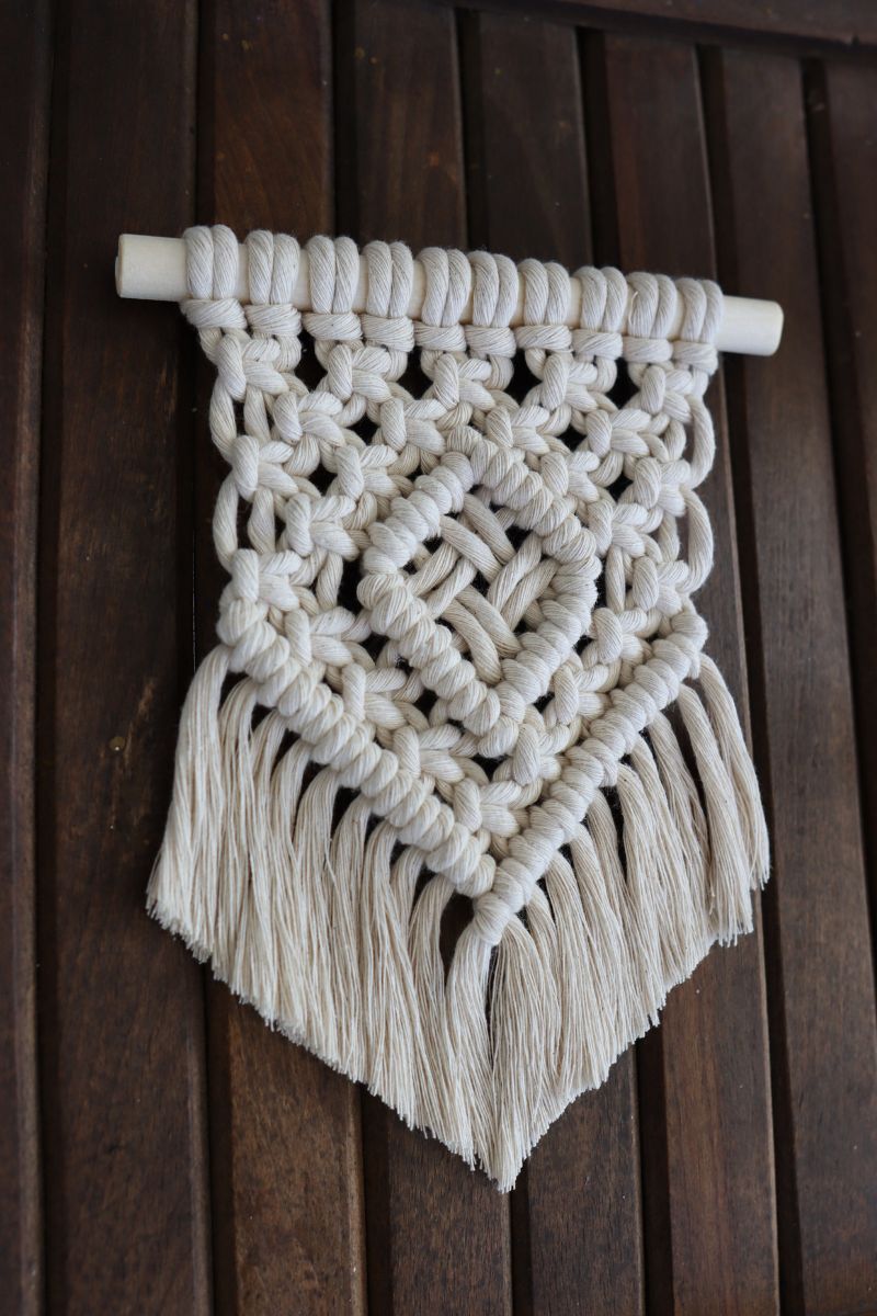 finished Auda mini macrame wall hanging on a wooden background